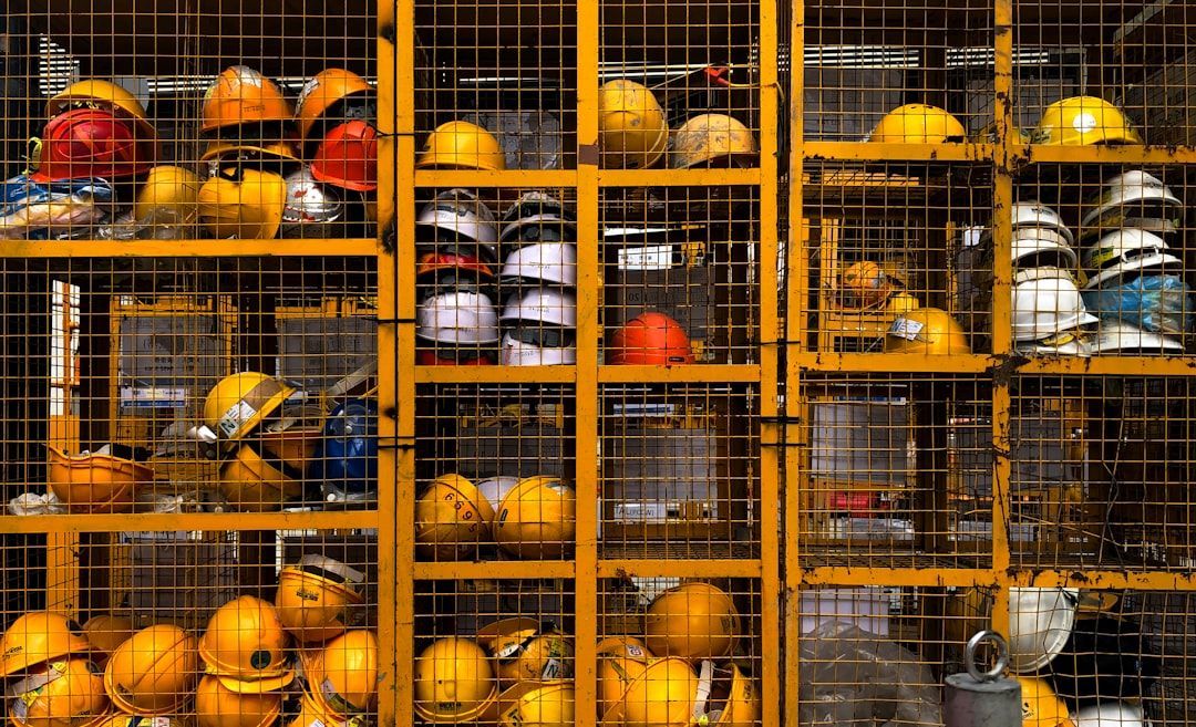 A bunch of hard hats are stacked on top of each other in a cage.