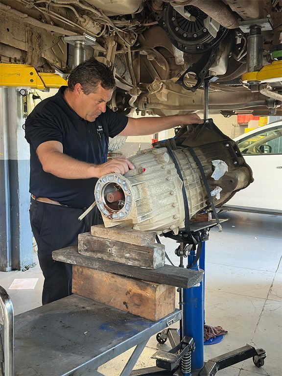 Mechanic inspecting a car transmission on a lift in an auto repair shop | Marin Automotive