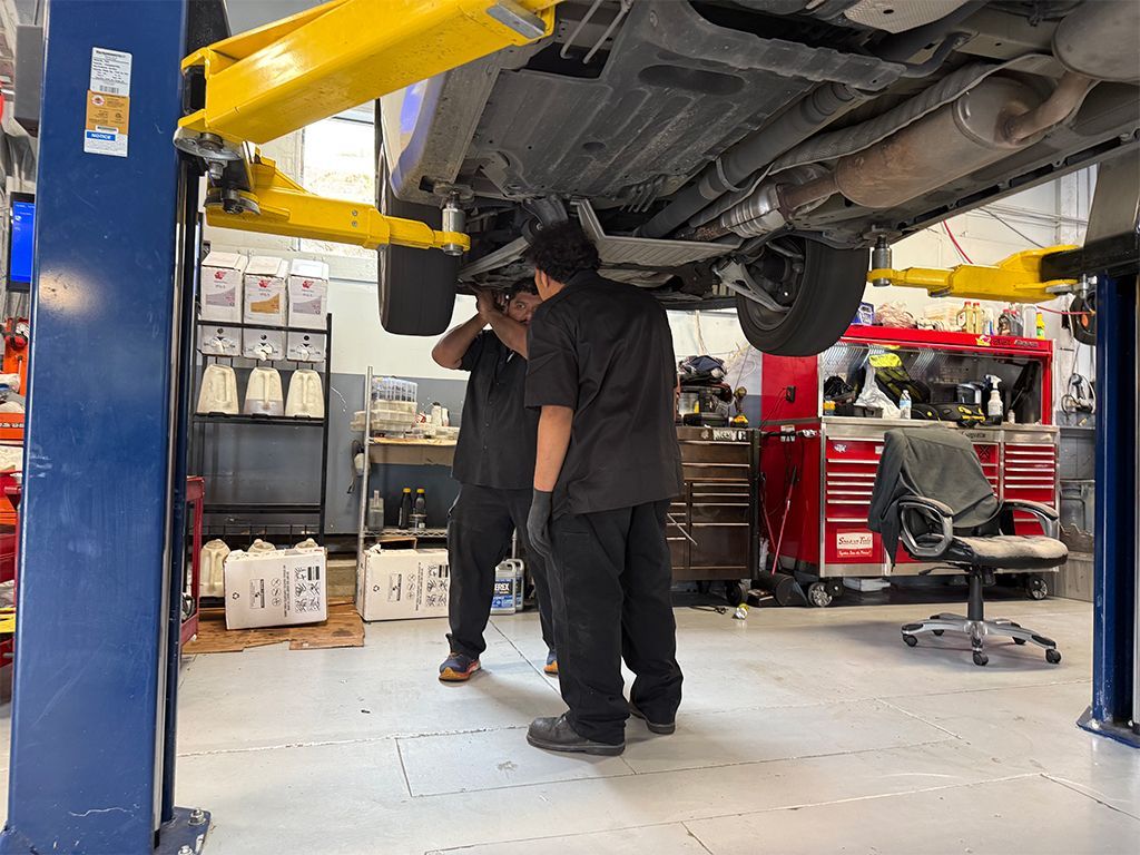 Mechanic inspecting a car on a lift in an auto repair shop | Marin Automotive