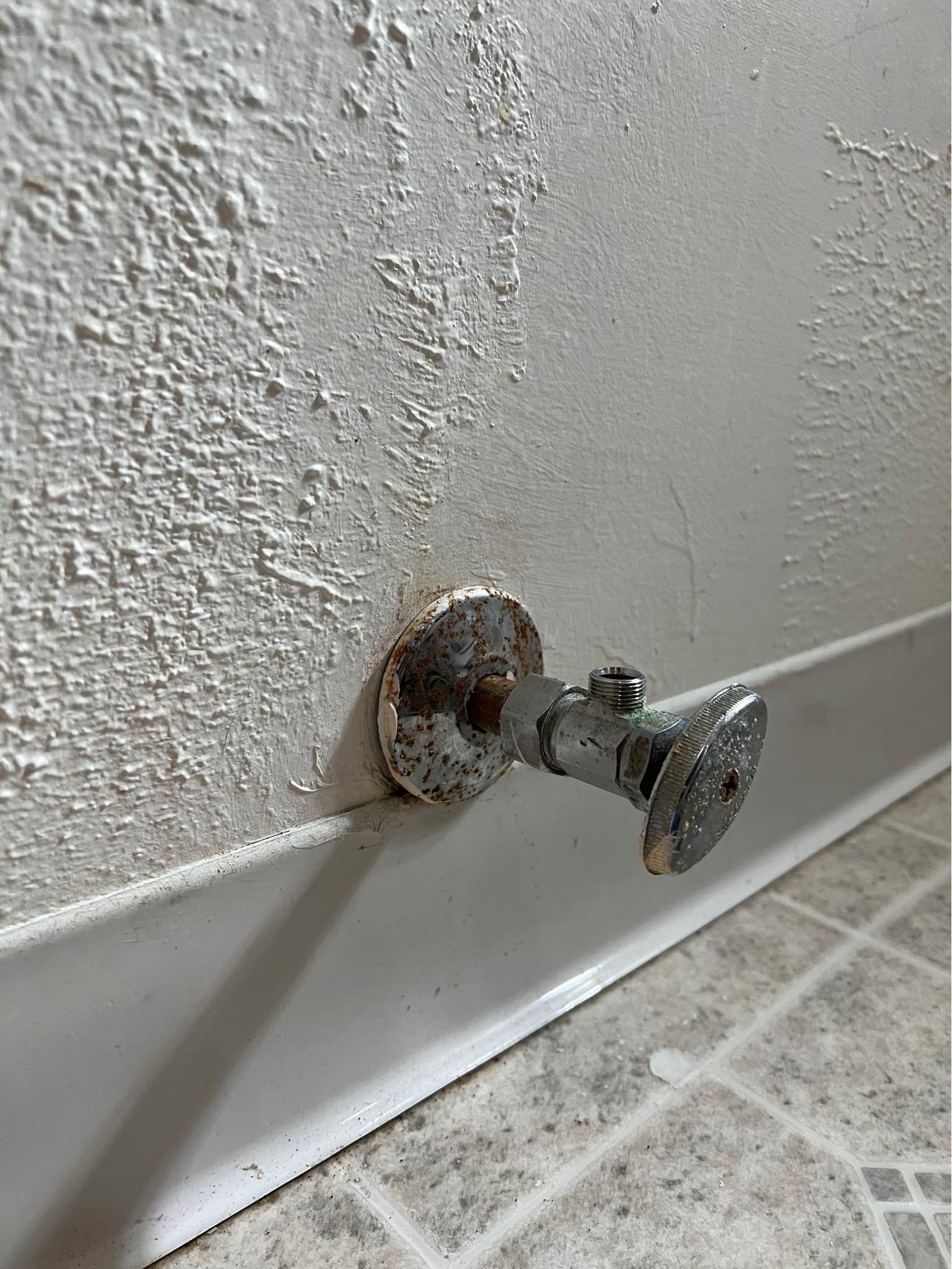 A close up of a water valve on a wall.