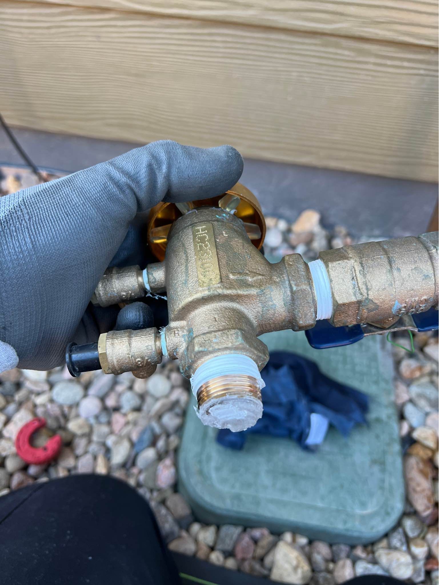 A person is holding a brass valve in their hand.