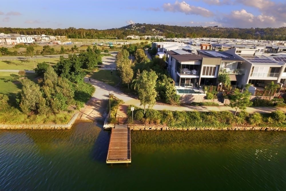 An Aerial View of a Large House Next to a Body of Water — Core Pest Management in Maroochydore, QLD