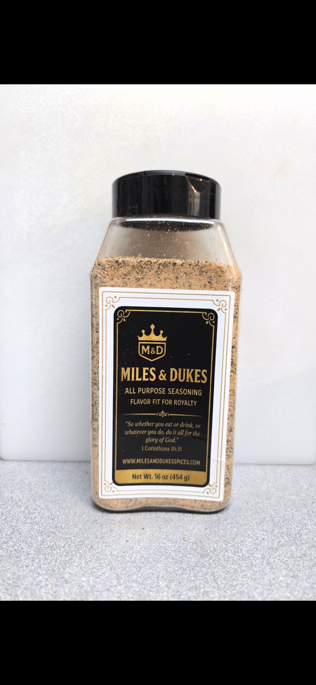 A square bottle of Willis & Duvn honey with a black cap on a light surface.