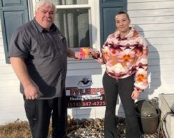 A man and a woman are standing in front of a house.