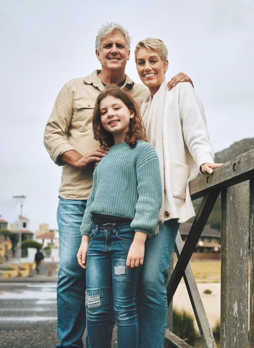 A family is posing for a picture on a bridge.