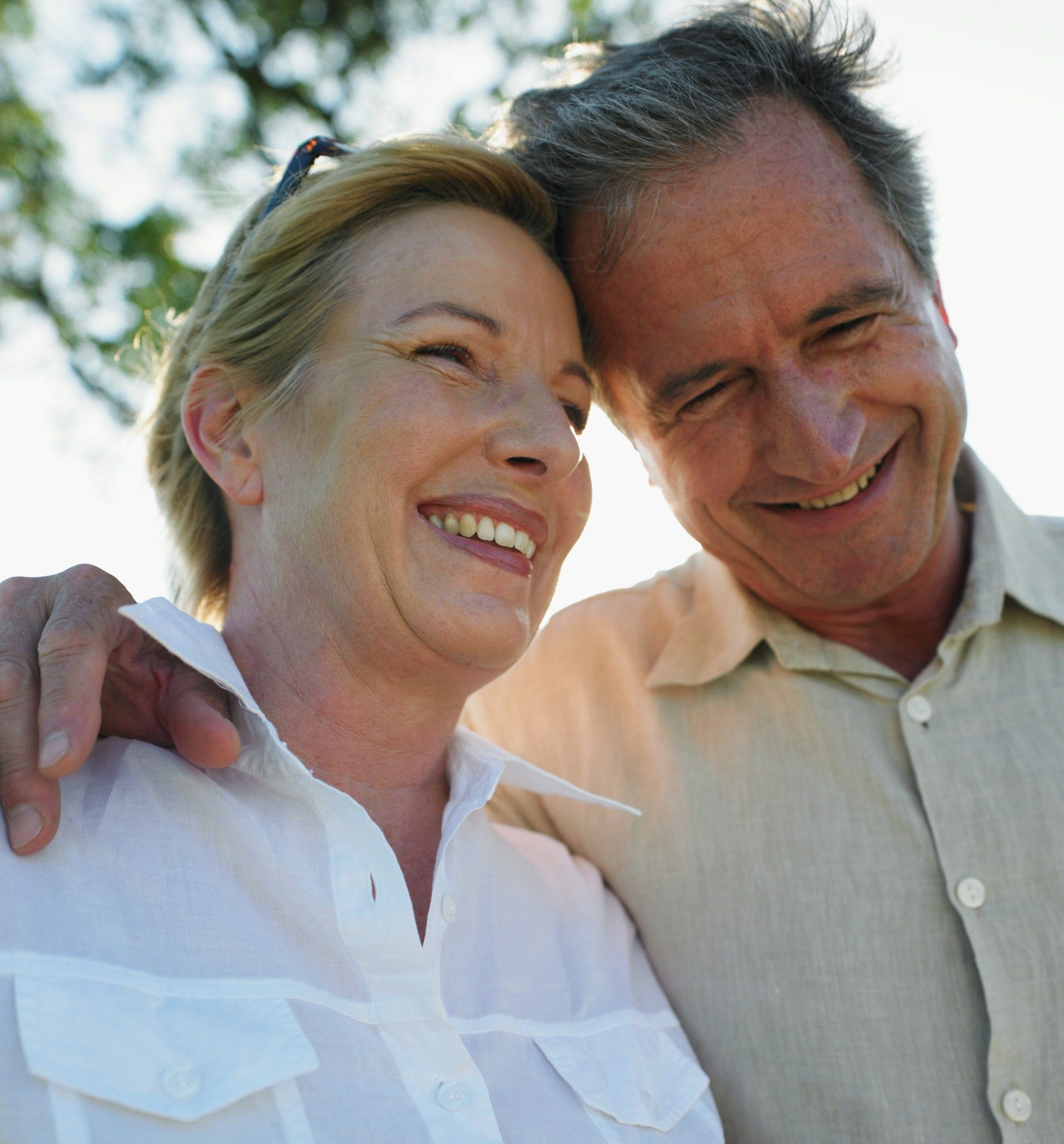A man and a woman are smiling and hugging each other