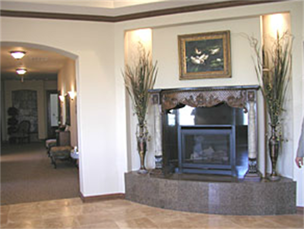 Living room with stone fireplace, framed art, and tall decorative vases in a neutral interior