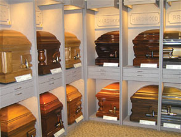 Rows of wooden coffins displayed on shelves in a funeral home showroom