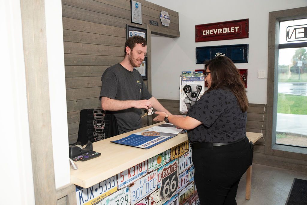 Customer paying at a shop counter with a clerk handing over a card reader