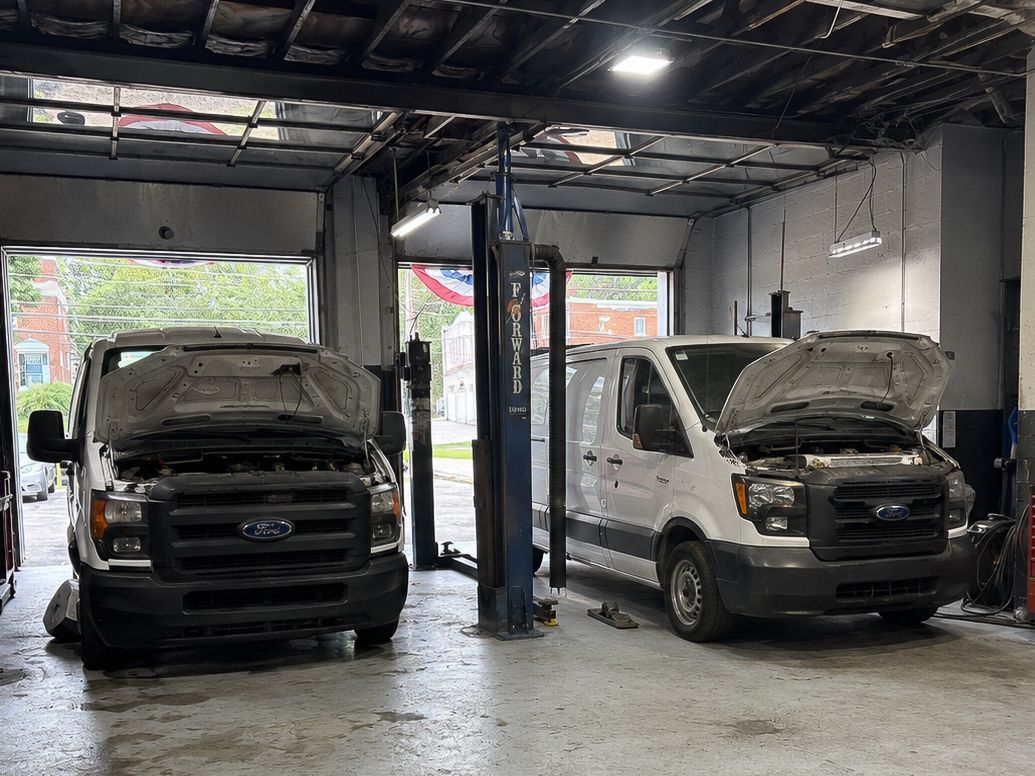 Two vans with raised hoods inside Briarcliffe Auto Service.