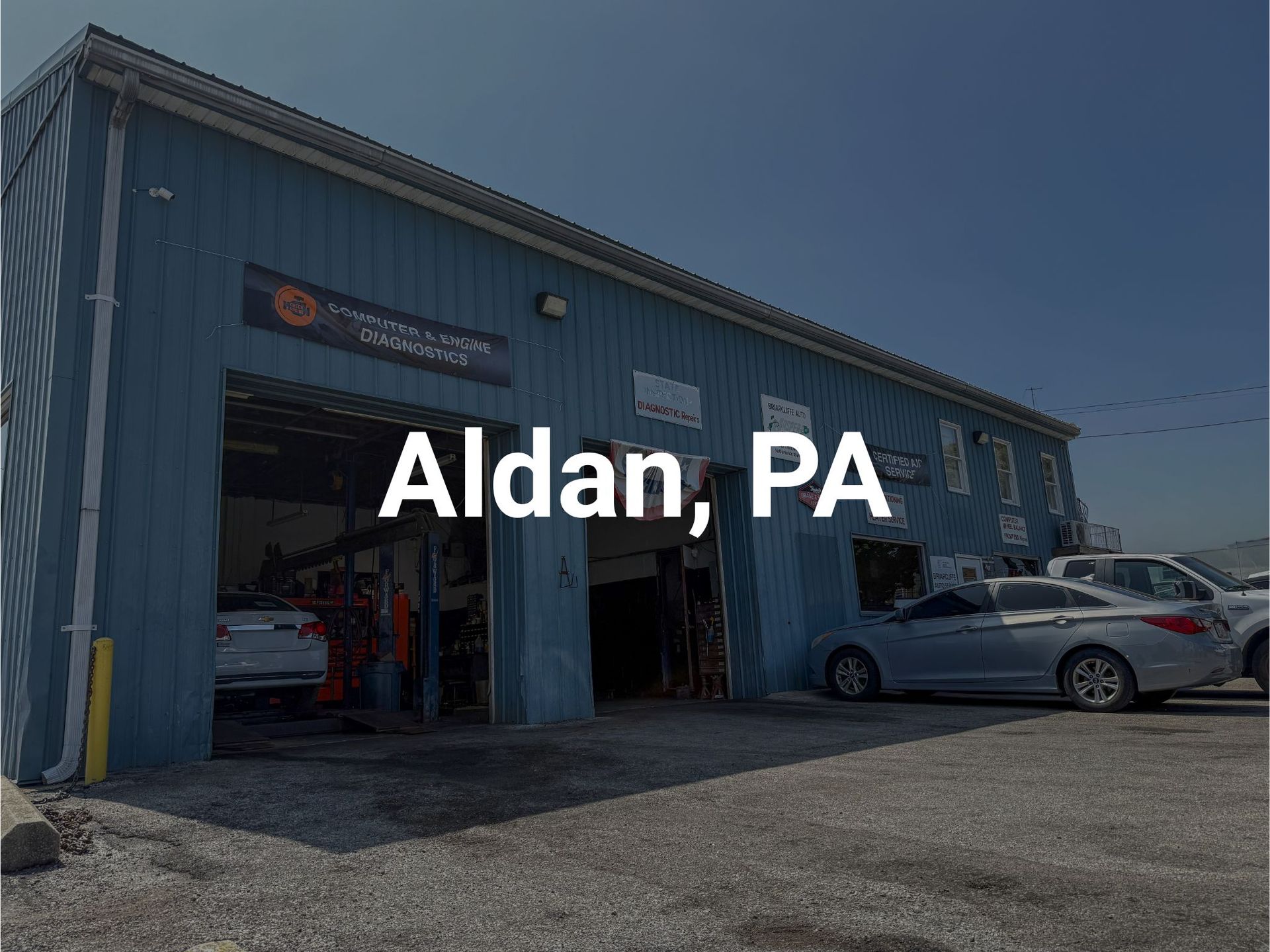 Briarcliffe Auto Service shop in Glenolden, PA with open bay doors. Several cars are parked outside in a parking lot.