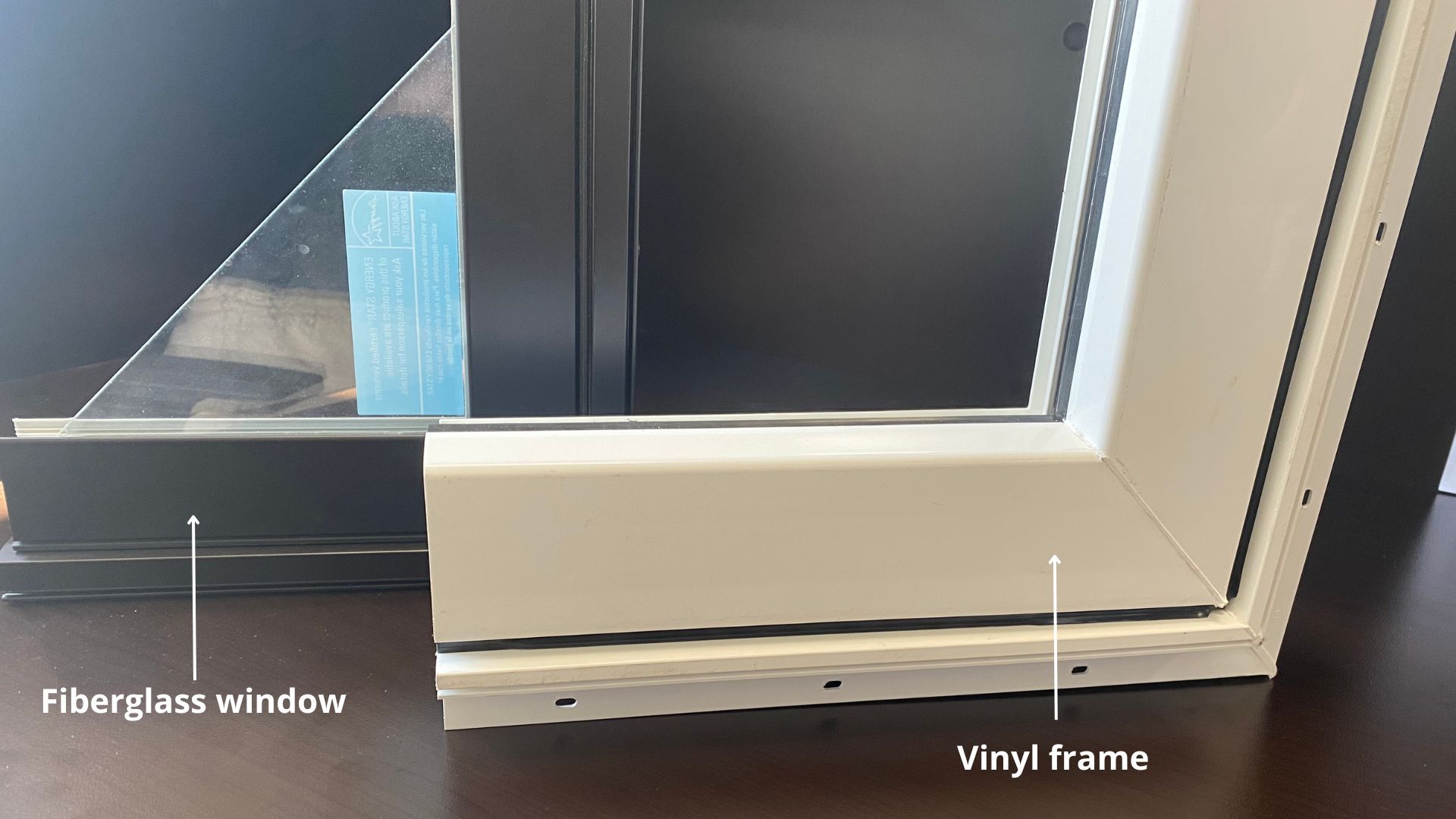 A fiberglass window with a vinyl frame is sitting on a wooden table.