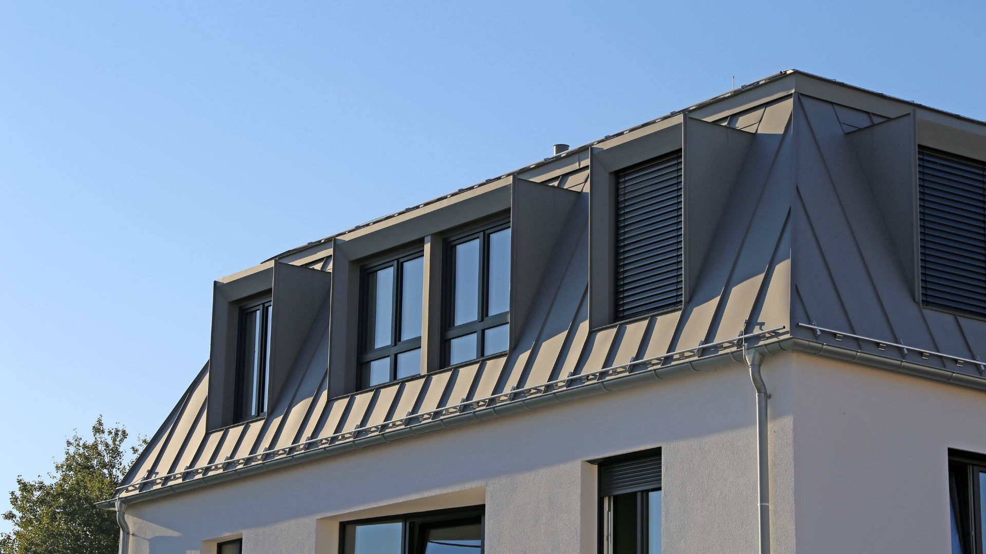 A white house with a gray roof and a balcony