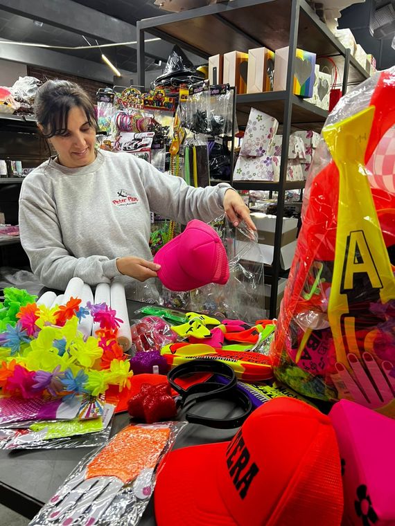 Artesanías coloridas hechas a mano y velas dispuestas en un puesto de mercado con cestas tejidas y adornos colgantes.