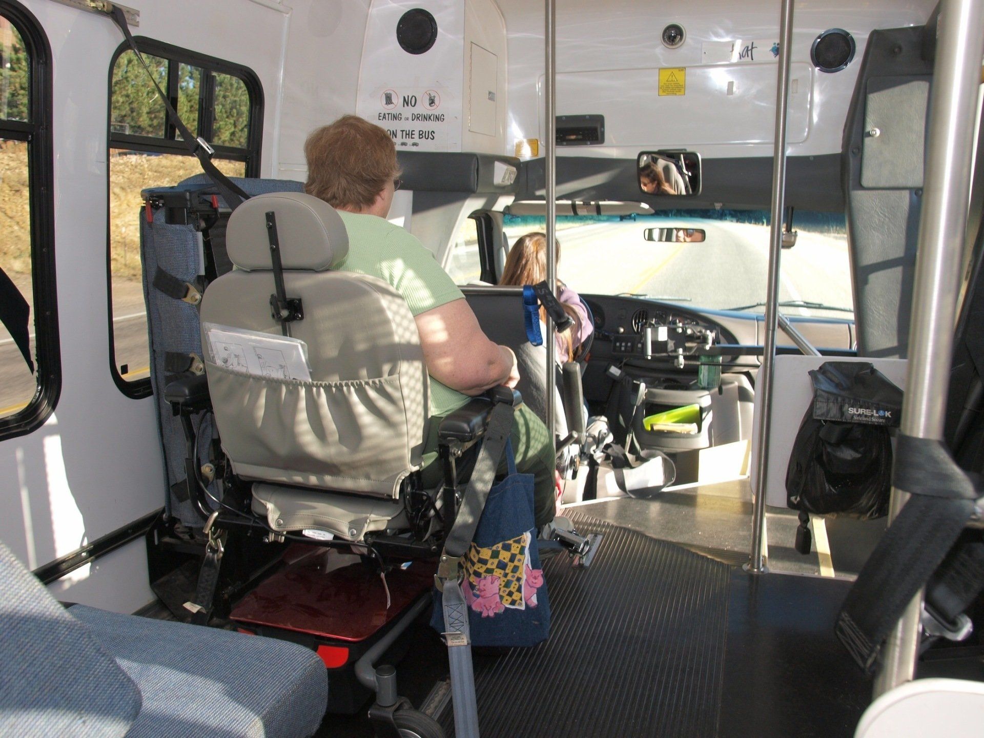 Paratransit interior with passenger in mobility chair.