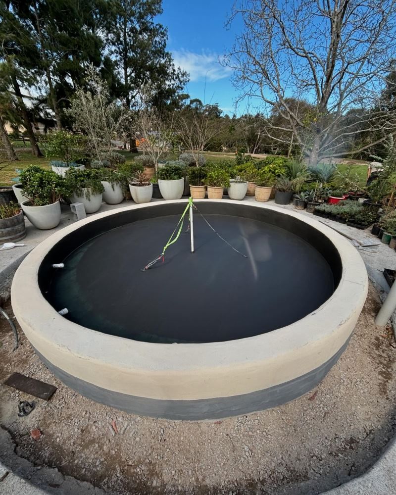 A Large Circle Of Water Is Surrounded By Potted Plants — Coastwide Waterproofing in Terrigal, NSW