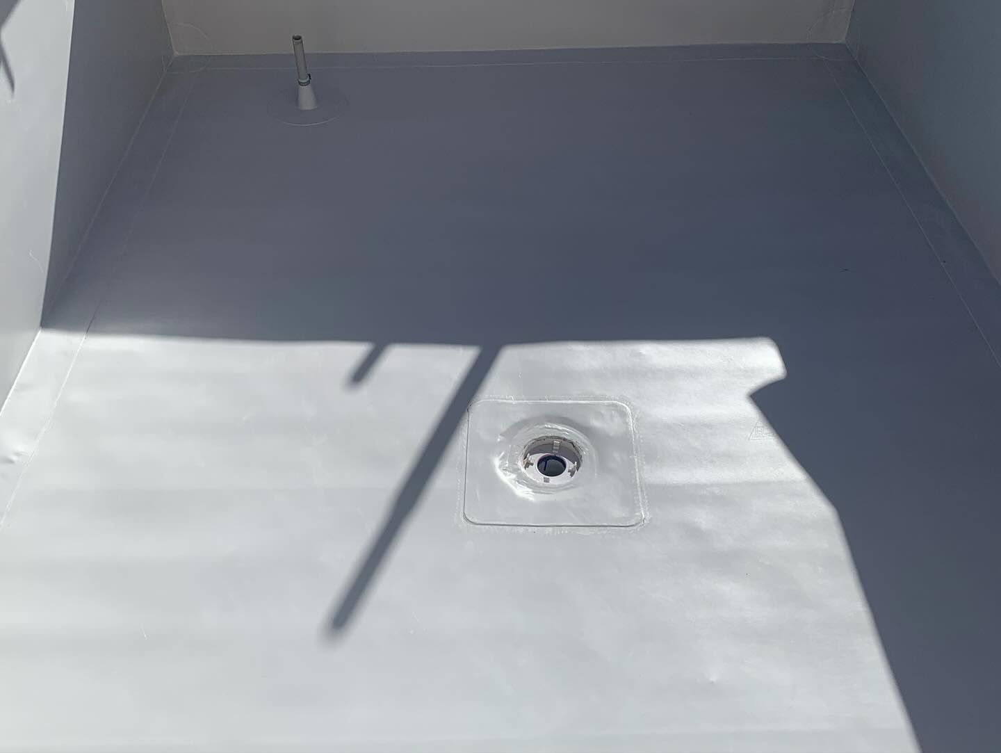 A White Floor With A Drain In The Middle Of It — Coastwide Waterproofing in Narrabeen, NSW