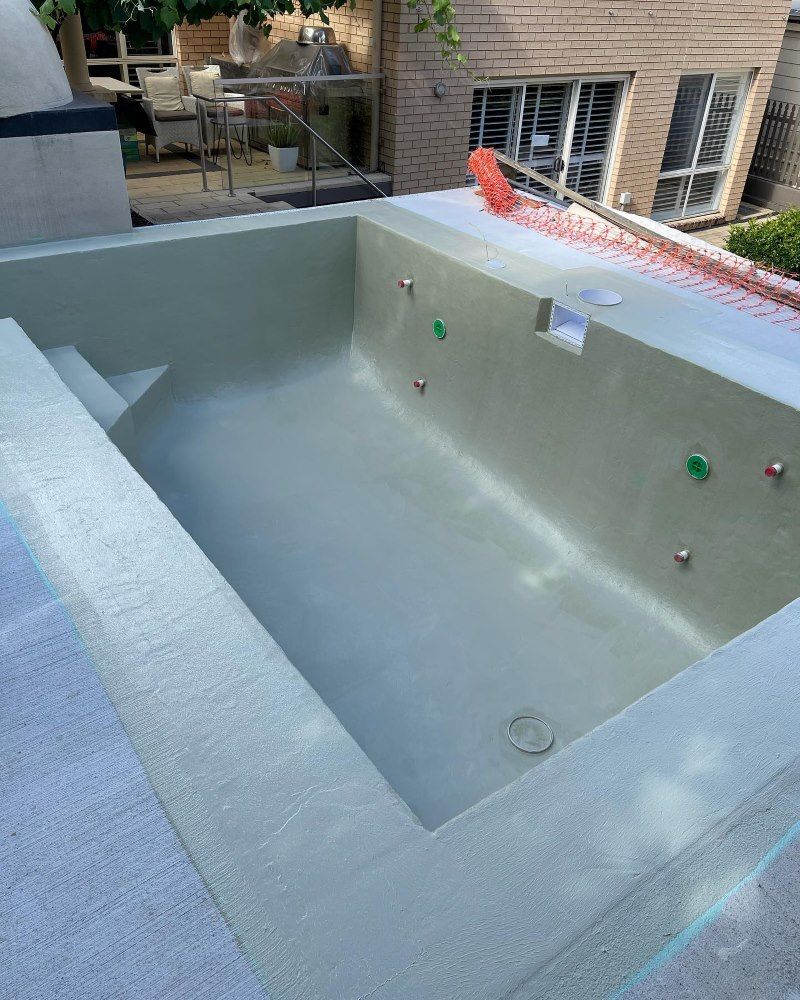 A Large Swimming Pool Is Being Built In The Backyard Of A House — Coastwide Waterproofing in Hornsby, NSW