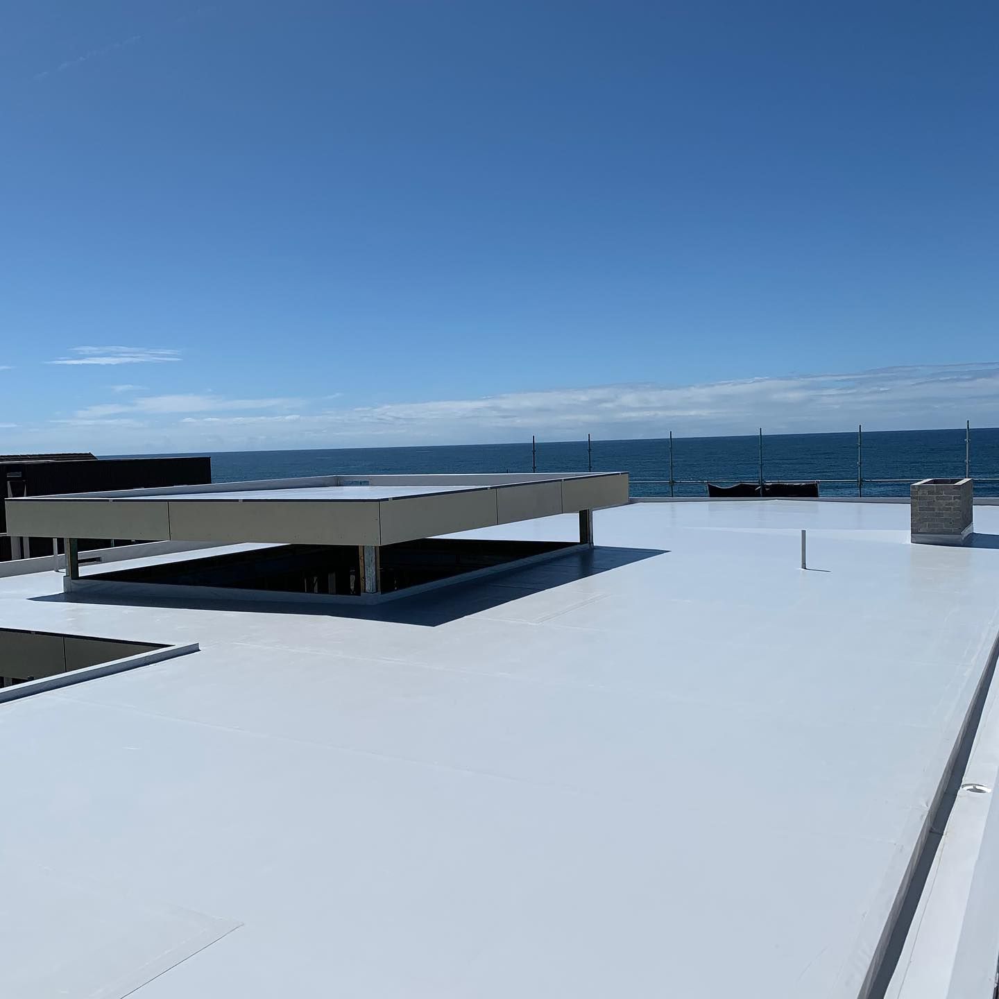 A White Roof With A View Of The Ocean On A Sunny Day — Coastwide Waterproofing in Woy Woy, NSW