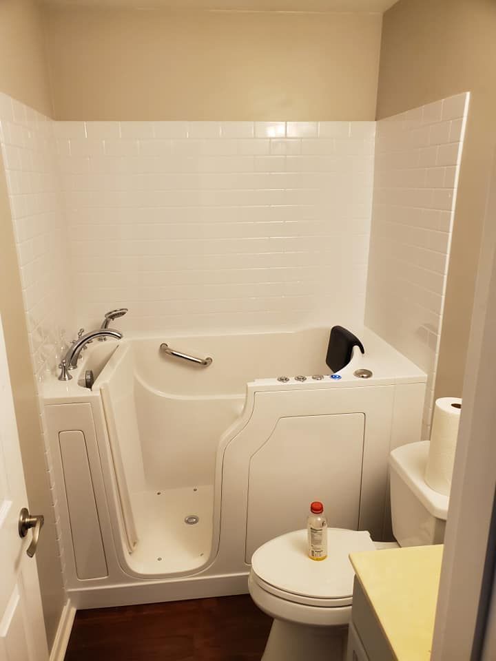 A bathroom with a walk in tub and a toilet.