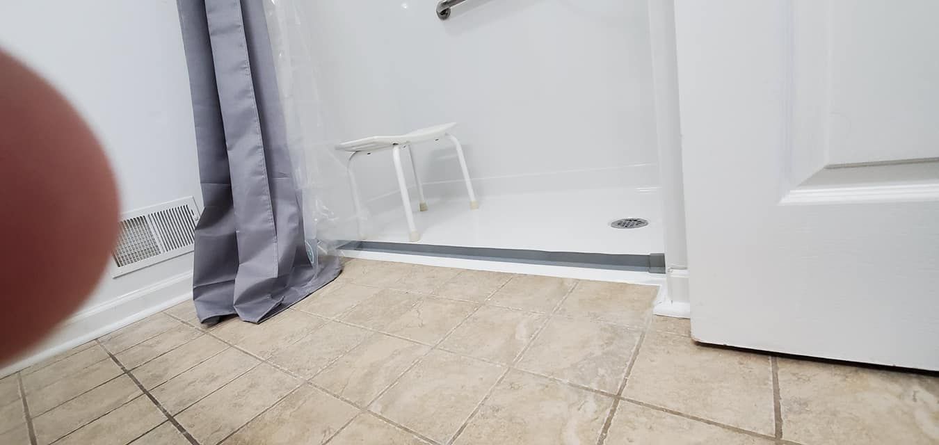 A bathroom with a walk in shower and a door.
