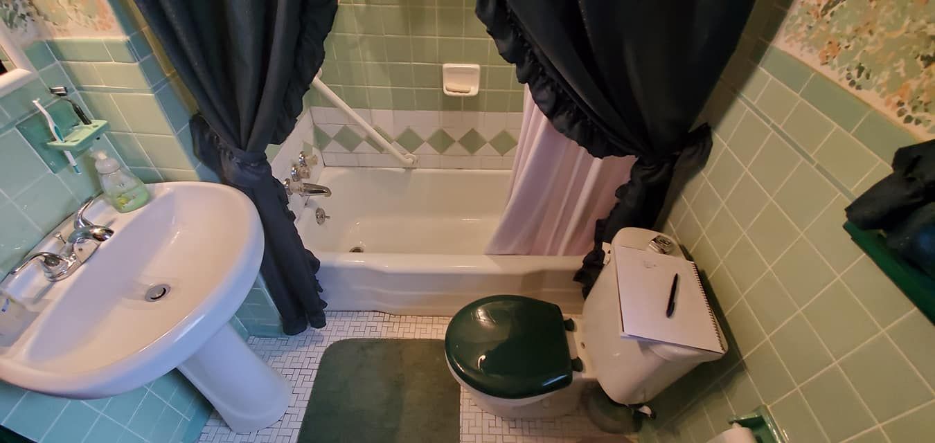 A bathroom with a sink , toilet , bathtub and shower curtain.