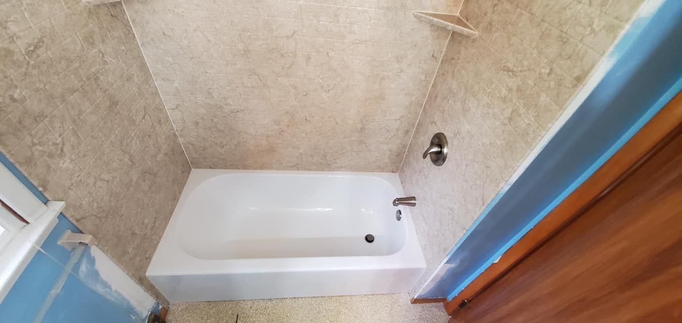 A bathroom with a bathtub and a shower.