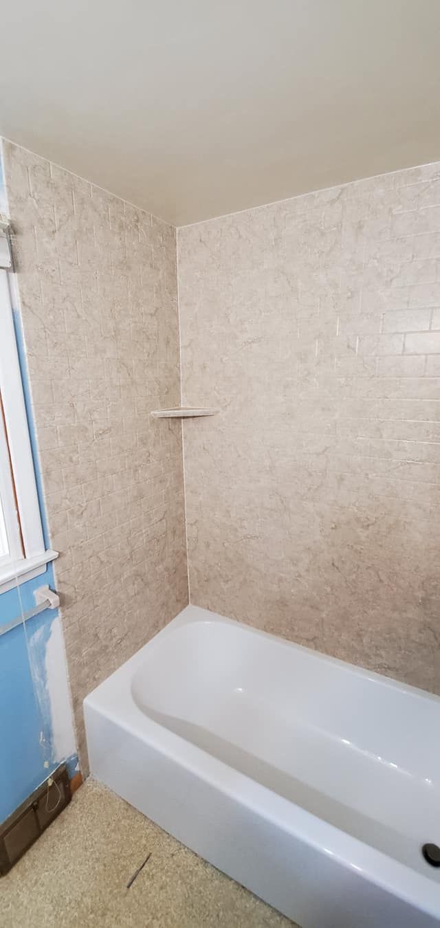 A bathroom with a bathtub and a shower.