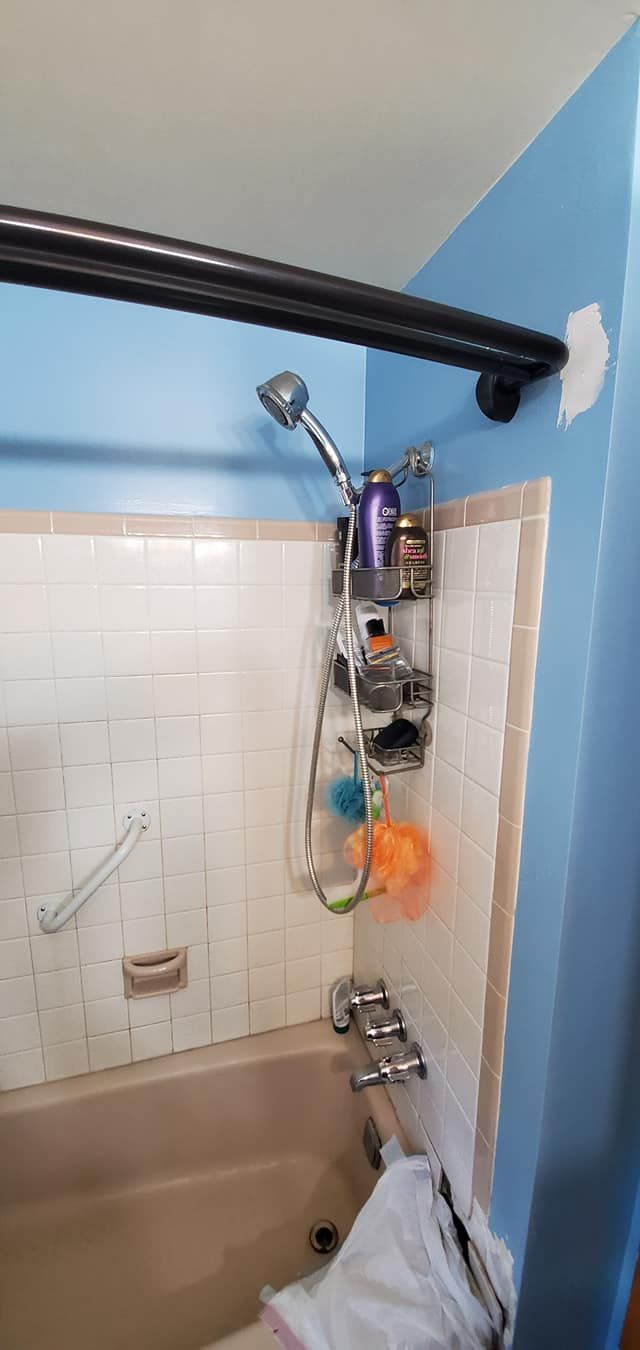 A bathroom with a bathtub and a shower head.