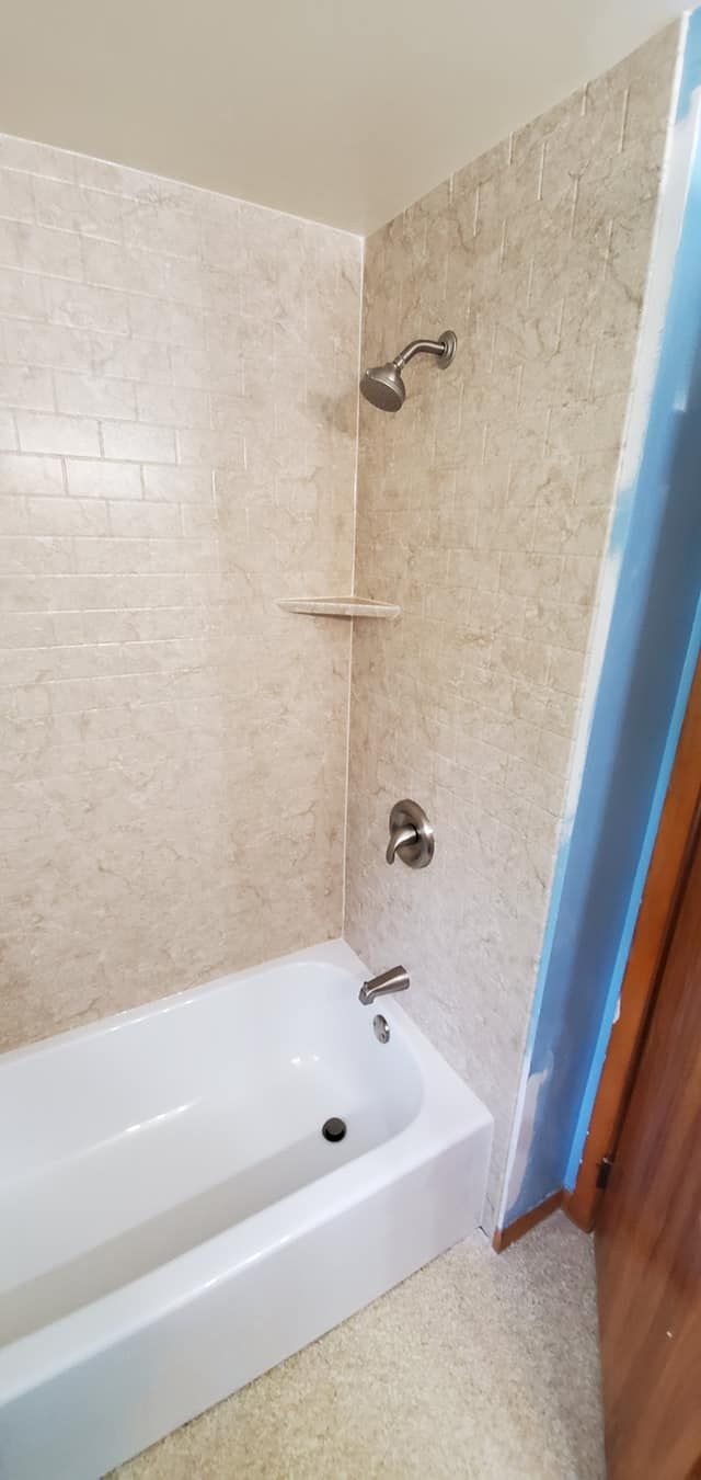 A bathroom with a bathtub and a shower.