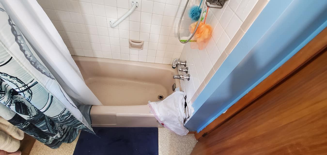 A bathroom with a bathtub and a shower curtain
