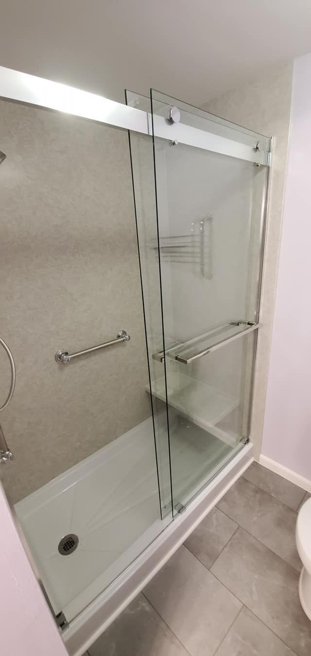 A bathroom with a sliding glass shower door and a toilet.