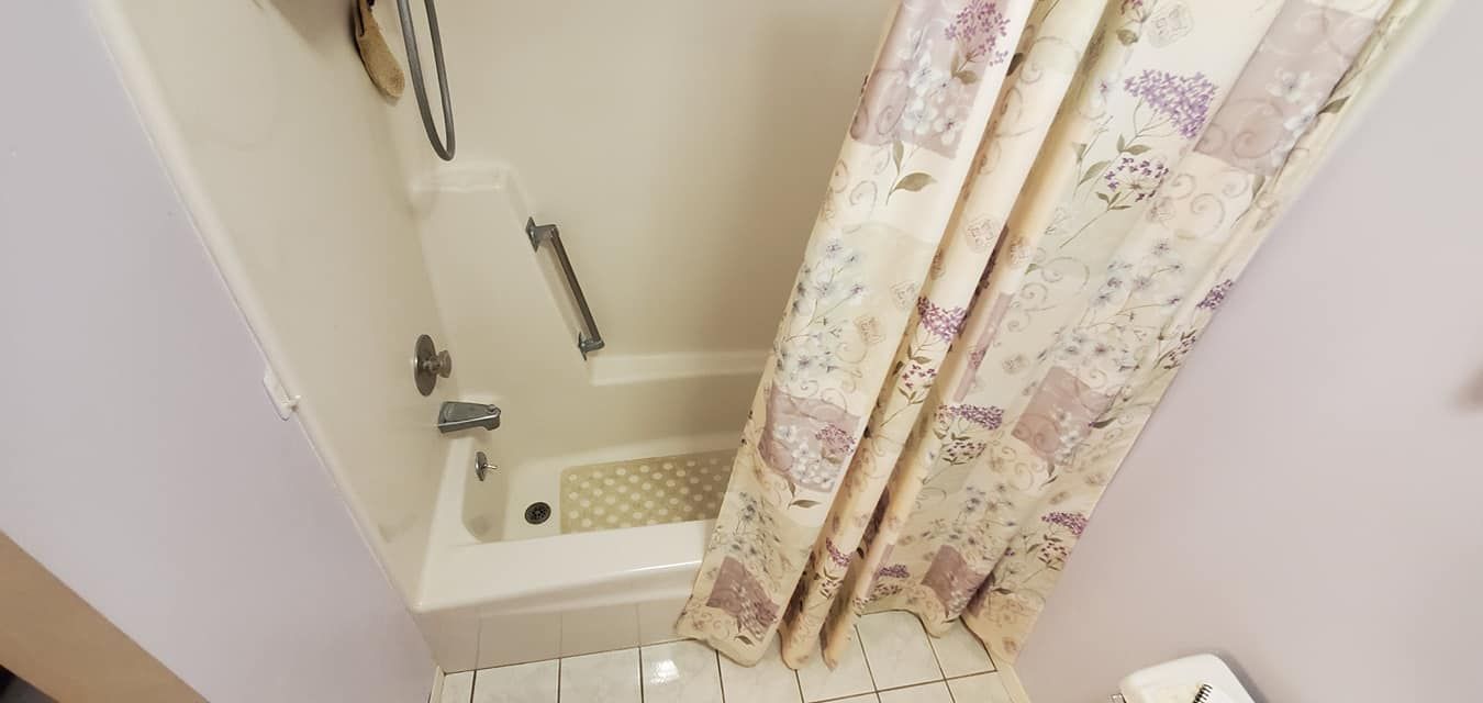 A bathroom with a shower curtain and a bathtub.