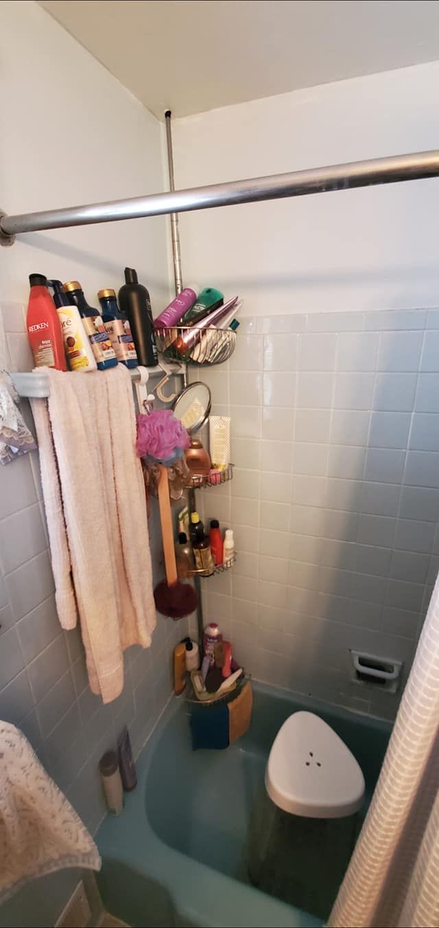 A bathroom with a bathtub , toilet and shower curtain.
