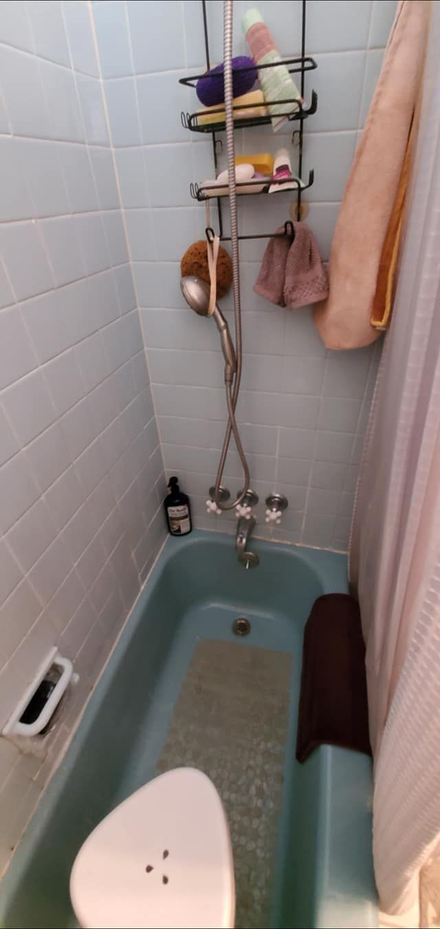 A bathroom with a bathtub and a shower.