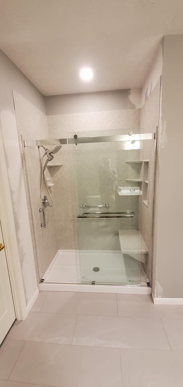 A bathroom with a walk in shower and a sliding glass door.