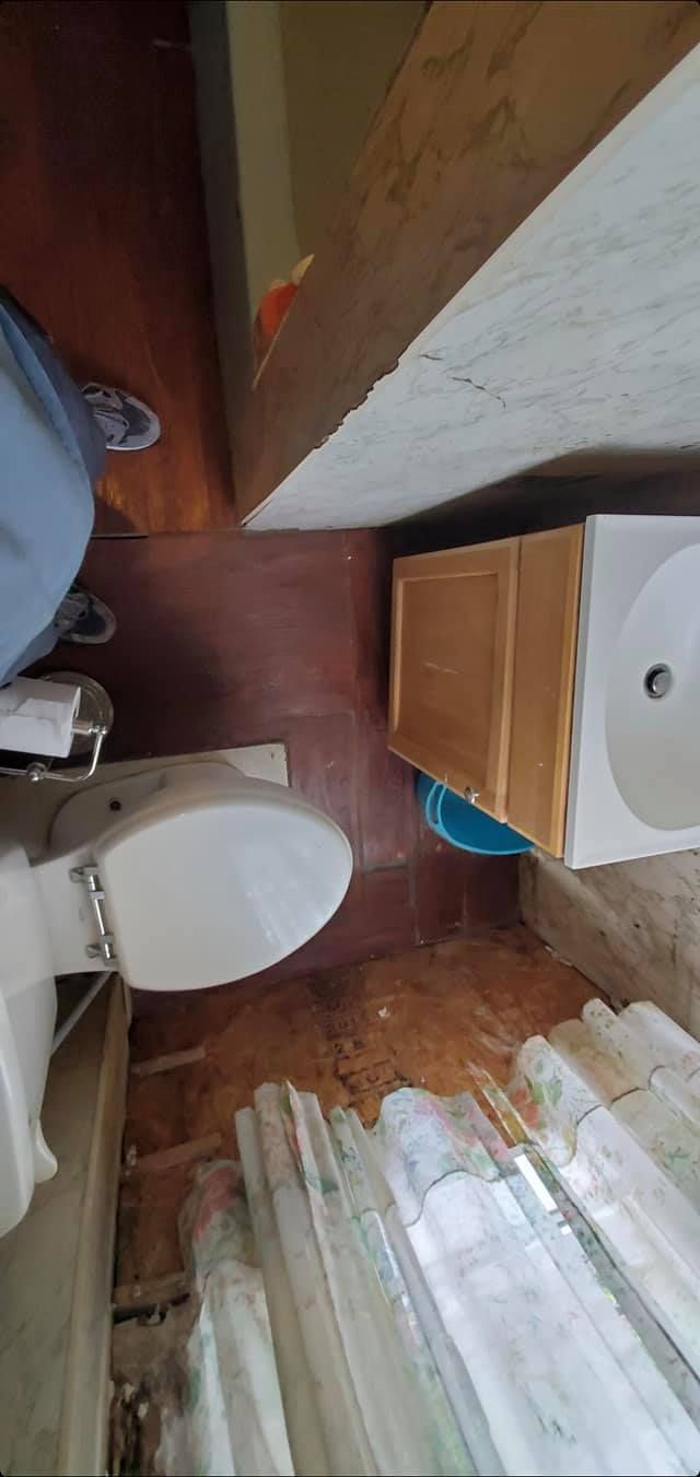 A bathroom with a toilet , sink and cabinets.