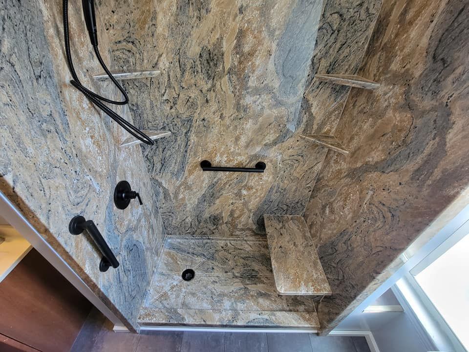 A bathroom with a walk in shower and a bench.
