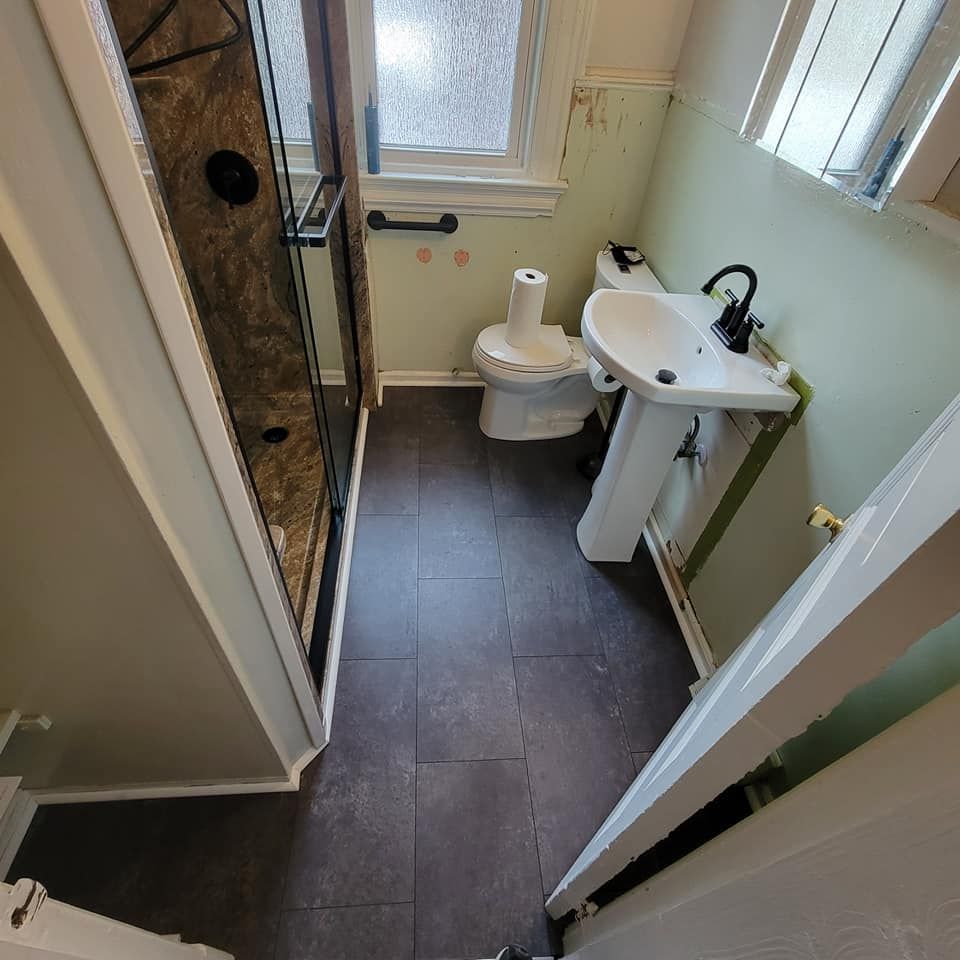 A bathroom with a toilet a sink and a shower