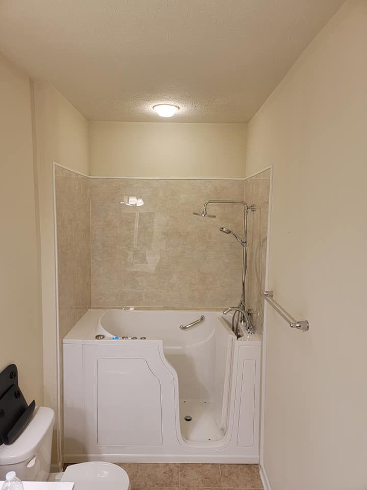 A bathroom with a walk in tub and a toilet.