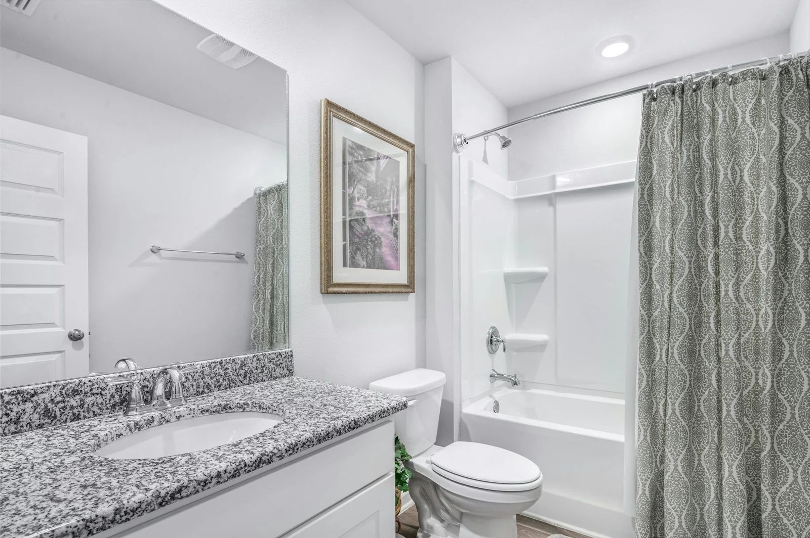 Modern bathroom with granite vanity and tub.