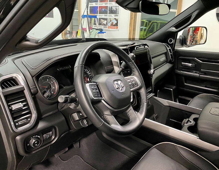 Black Toyota SUV interior with steering wheel, dashboard, and front seats viewed from the driver’s side