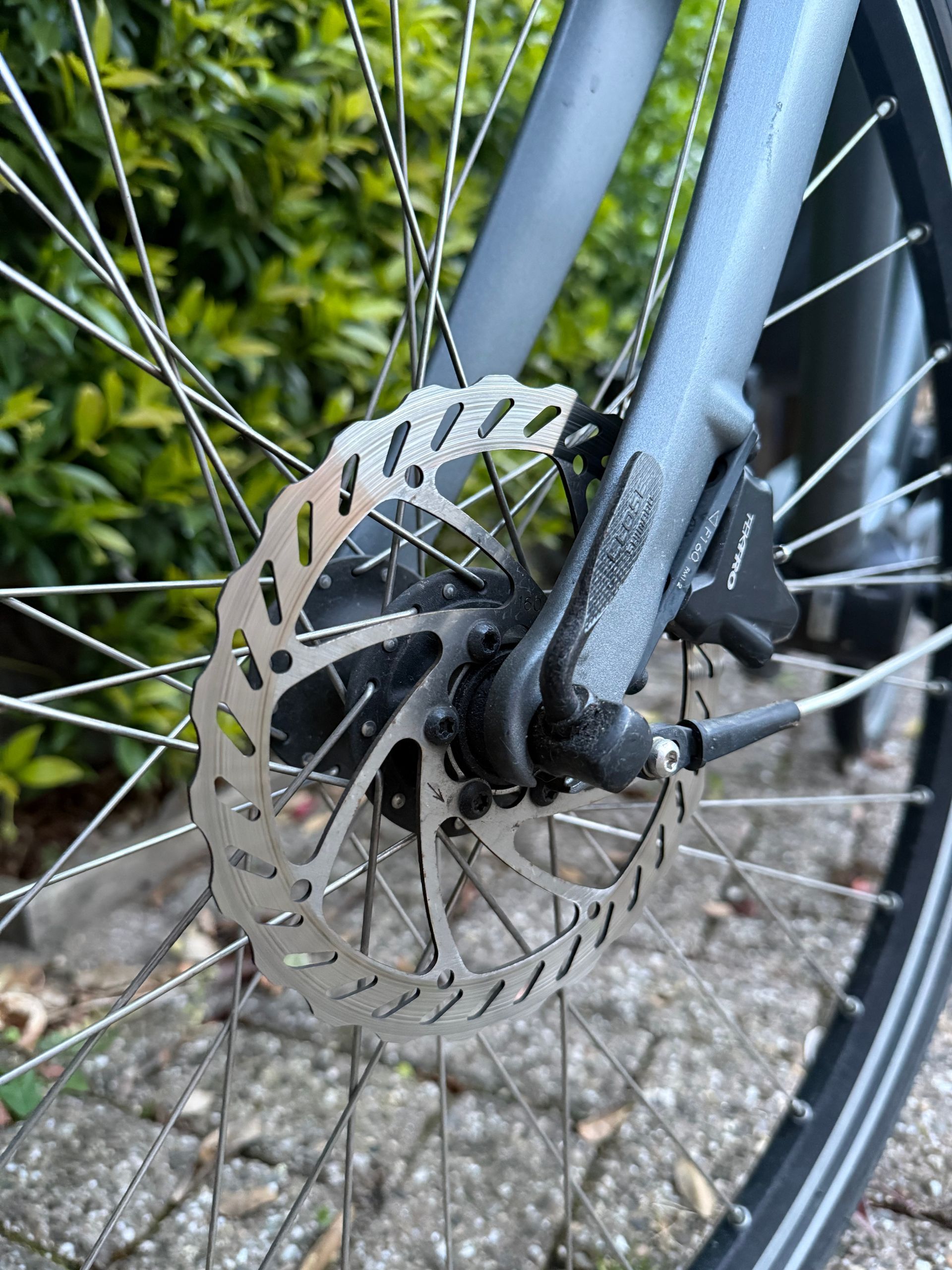 Handmatig afstellen van een blauwe snelspanner van de fiets nabij de voorwielrem.