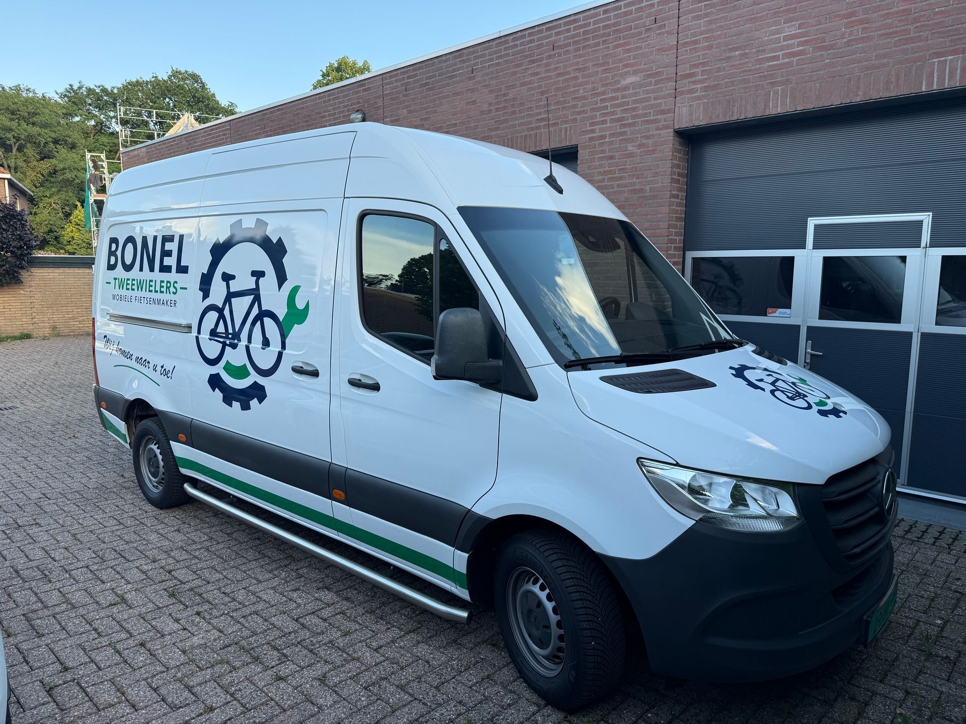 De belettering van de BONEL Techniciens-bestelwagen in wit en blauw, weergegeven vanuit zij-, voor- en achteraanzicht.