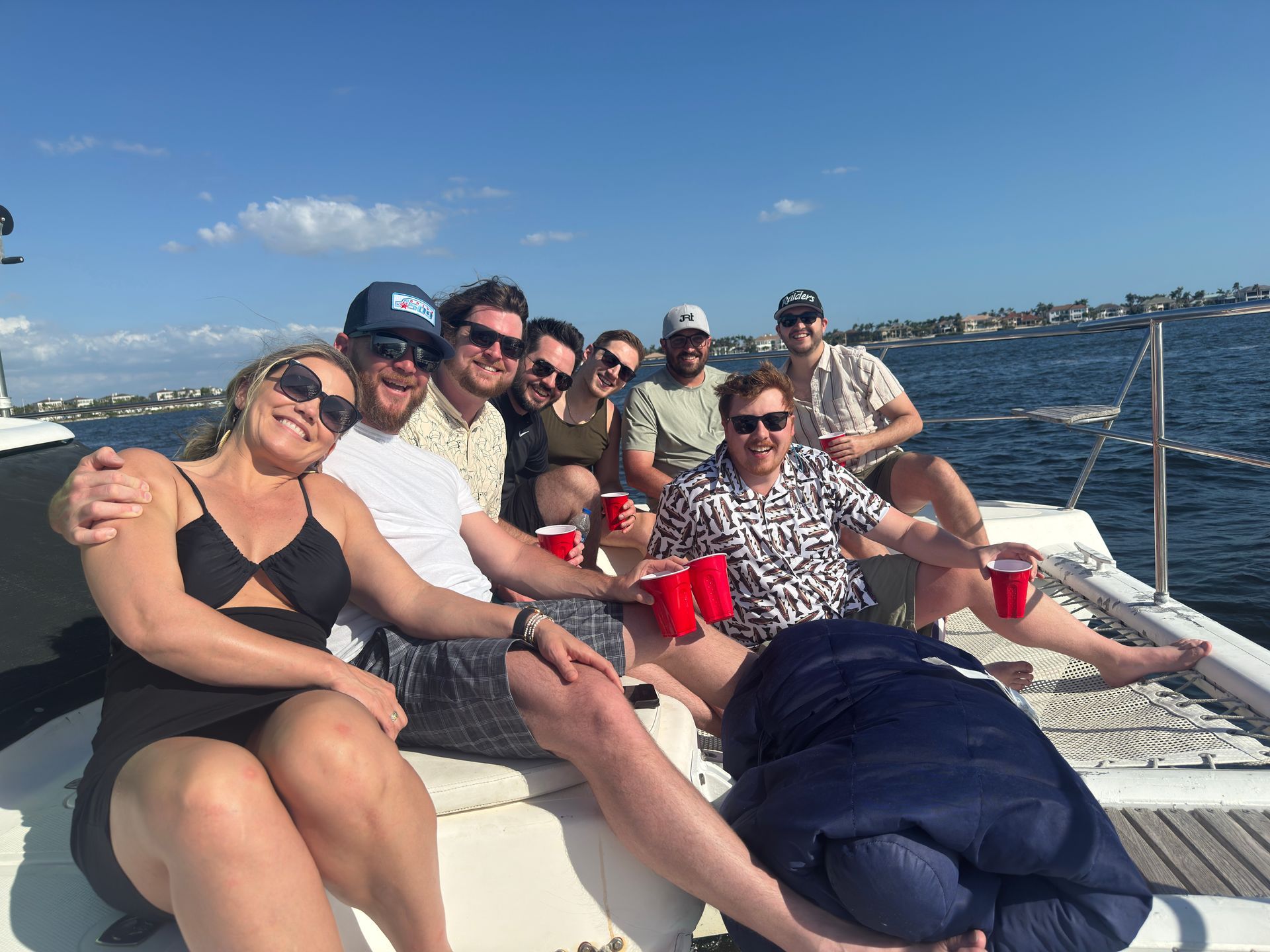 CDL PowerSuite team smiling and posing on deck with a red cup in the foreground.