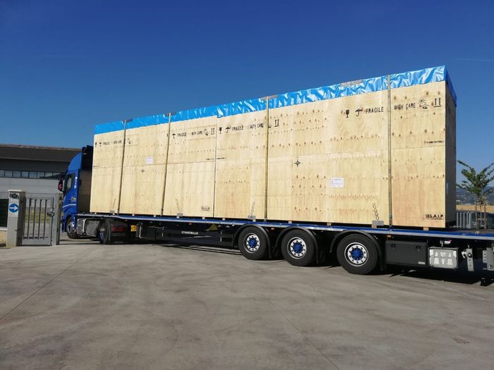Grande cassa di legno su un camion a pianale in un'area industriale.