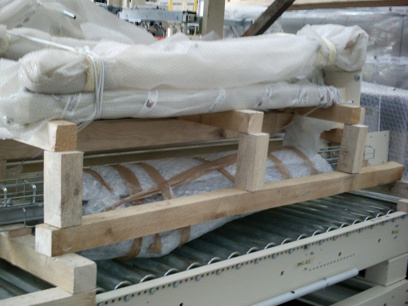 Cassa di legno contenente componenti industriali imballati su un nastro trasportatore di fabbrica