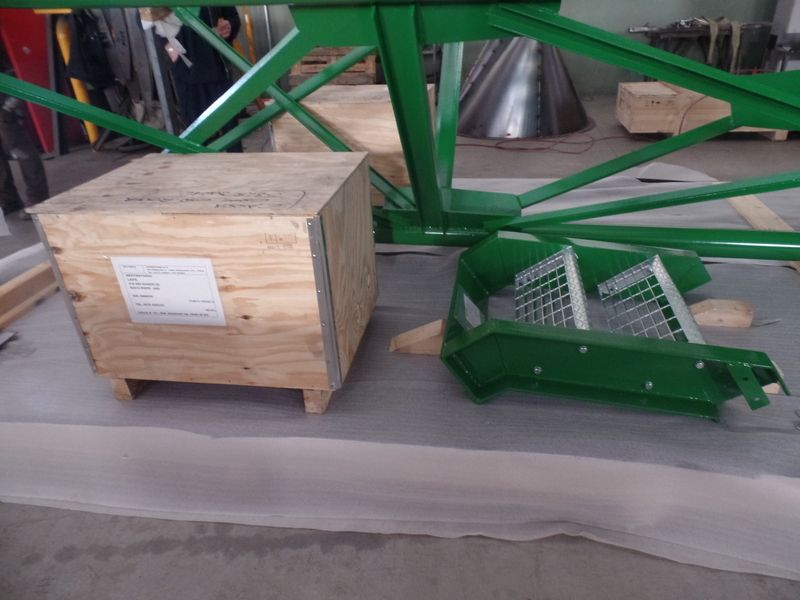 Cassa di legno e nastro trasportatore in metallo verde in un'officina industriale.