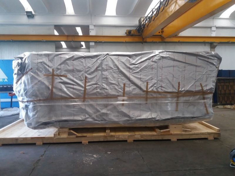 Grande spedizione pallettizzata e imballata su un pallet di legno in un magazzino industriale.