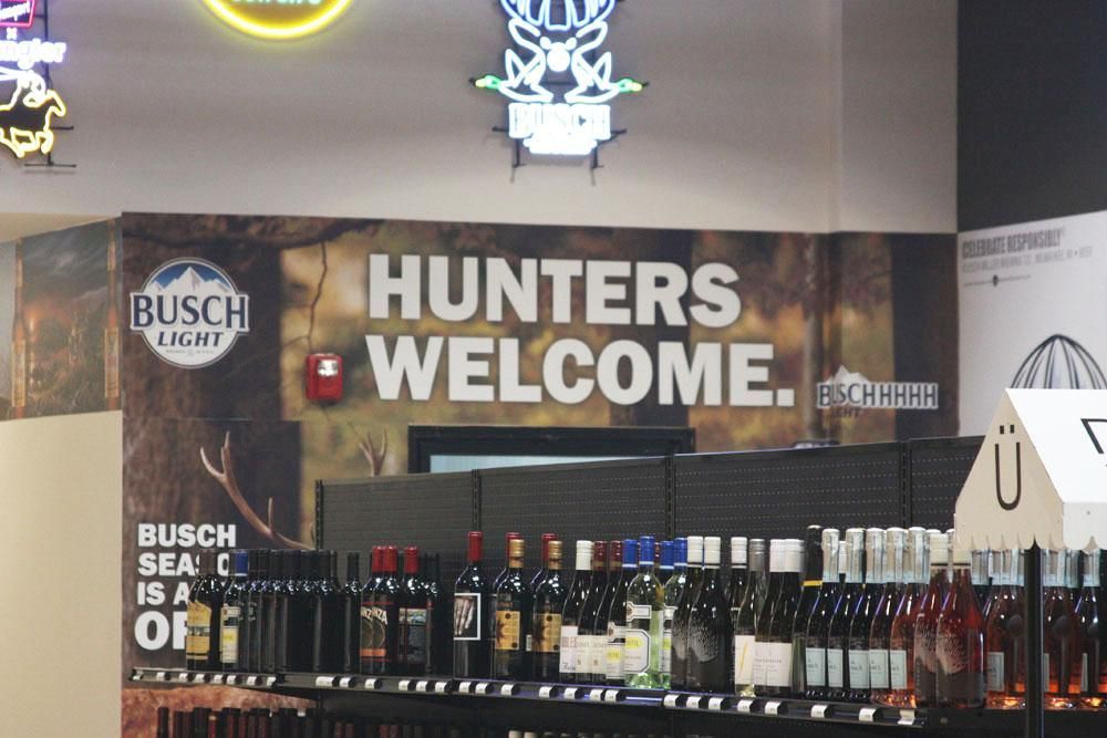 Store display shelf with wine bottles under a